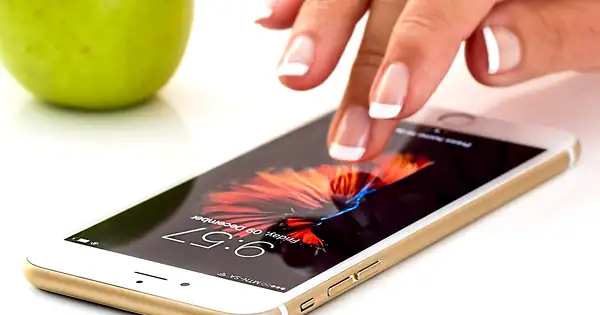 Doigt touchant l’écran d’un smartphone pour activer une application